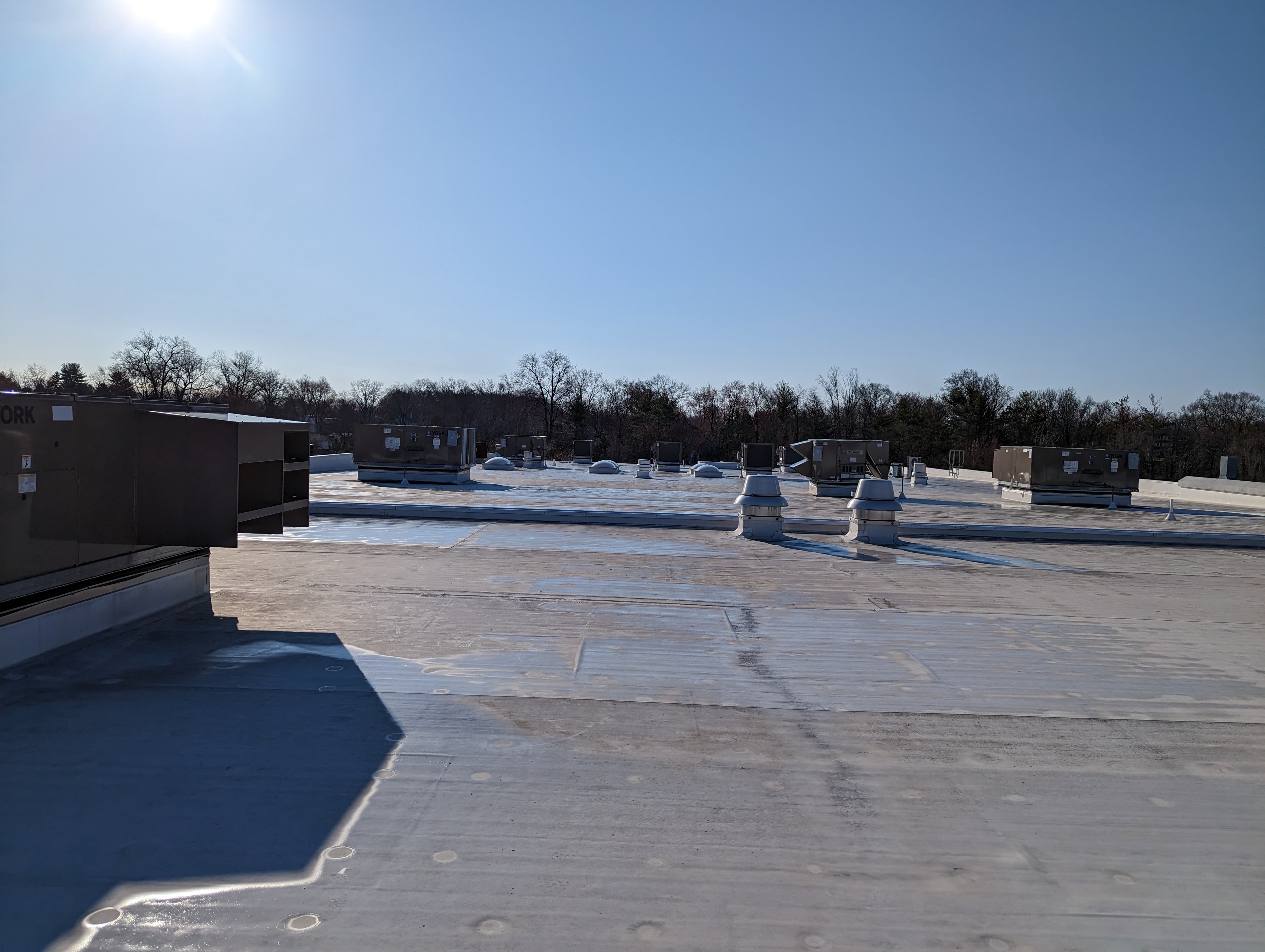 Commercial rooftop with multiple HVAC units on flat roof — commercial duct cleaning NJ