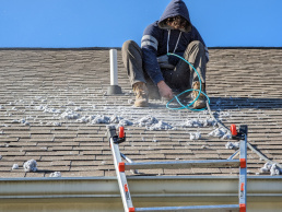 Man cleaning a roof dryer vent clogged with lint in Howell